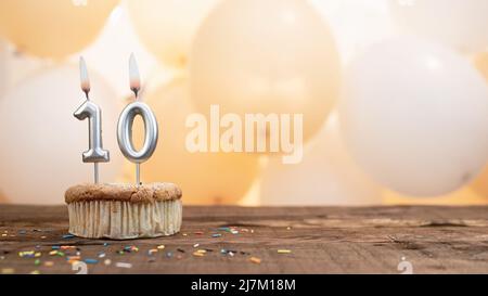 Happy birthday card with a candle in a cupcake against the background of balloons. Copy space happy birthday with cupcake digit Stock Photo