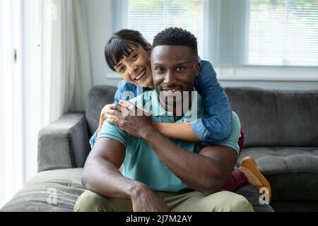 Portrait of happy multiracial young couple spending leisure time together at home Stock Photo