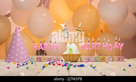 Beautiful background happy birthday number with lit candles, birthday candles in pink letters. Festive background with balloons Stock Photo