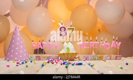 Beautiful background happy birthday number with lit candles, birthday candles in pink letters. Festive background with balloons Stock Photo