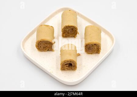 Roll cake with hazelnut and chocolate filling. roll cake on a white background. close up Stock Photo