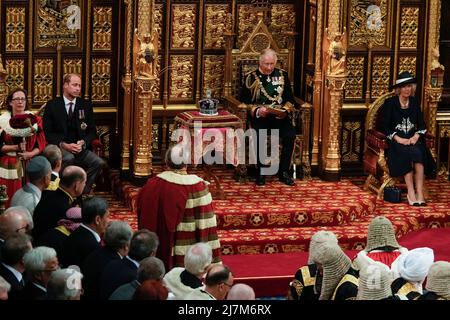 The Prince of Wales, , flanked by the Duke of Cambridge and the Duchess of Cornwall, delivers the Queen's Speech during the State Opening of Parliament in the House of Lords, London. Picture date: Tuesday May 10, 2022. Stock Photo