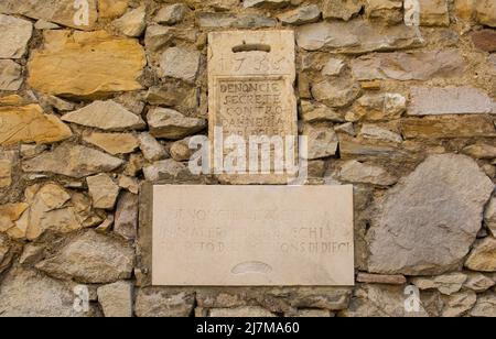 A medieval denunciation box in Buzet, Croatia. The Italian text says it is for the anonymous reporting of people damaging woodland in the province. Stock Photo