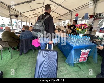 May 9, 2022, PrzemyÅ›l, Poland: PrzemyÅ›l Glowny ''” Main train station ''” May 9, 2022: Ukrainian refugees arrive with pets in carriers and luggage to eat and rest at the World Central Kitchen tent. A bouquet of flowers towards the entrance add a sweet and welcoming touch on Mother's day. (Credit Image: © Amy Katz/ZUMA Press Wire) Stock Photo