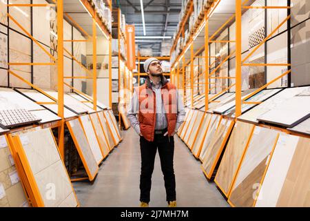 a buyer in a hardware store picks up ceramic tiles Stock Photo
