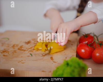 Young Girl Vlogger Making Social Media Video About Cooking At Home, looking on smartphone on tripod. episode about healthy eating. concept of attracti Stock Photo