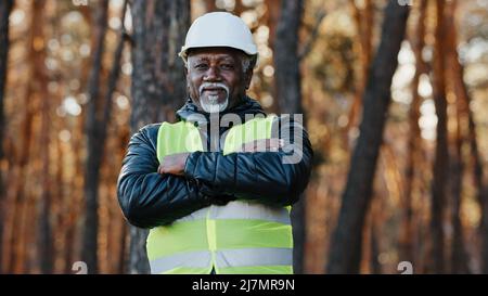 Mature african american confident male businessman standing outdoors professional forestry engineer foreman worker forester in uniform in protective Stock Photo