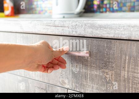 male hand are open the cupboard doors, light wood. Stock Photo