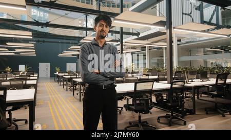 Indian male general office leader professional worker arab man businessman standing in office with arms crossed confident strong pose position project Stock Photo