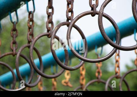old rusty rings on a chain on a horizontal bar for gymnastics on the street, sports ground in Ukraine Stock Photo