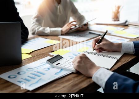 diverse businesspeople cooperate work together discussing company financial statistics, multiracial colleagues employees collaborate brainstorm with Stock Photo