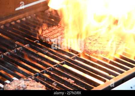 Flamed grilled beef burgers barbecued on an outdoor BBQ Stock Photo - Alamy