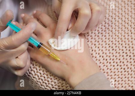 Doctor doing stem cell therapy on a patient's elbow after the injury. Treating knee pain with platelet-rich plasma injection. Treatment of arthritis a Stock Photo
