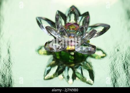 Crystal lotus on shiny green background with light reflection. Anahata chakra symbol. Stock Photo