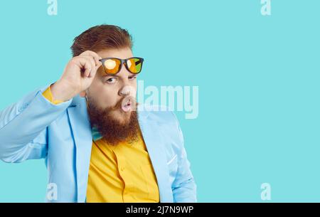 Funny chubby bearded man looks at you with expression of suspicion, doubt and disbelief on his face. Stock Photo