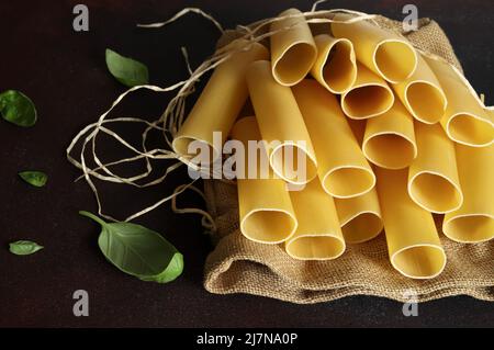 Cannelloni pasta tubes isolated on dark background. Italian food. Stock Photo