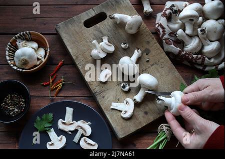 Fresh champignon mushrooms and ingredients for cooking on rustic background. Cooking organic mushroom. Directly above. Stock Photo