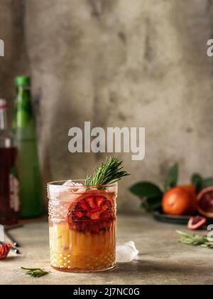 Delicious glass of iced cocktail with red orange. Still life composition in bar atmosphere. Vertical orientation Stock Photo