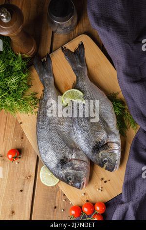 Raw peeled dorado fish with cooking ingredients. Fresh fish on a wooden background. Stock Photo