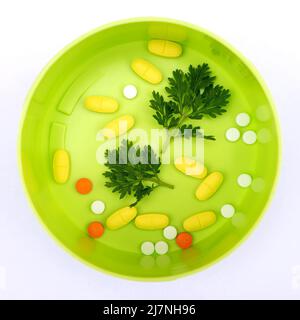 Pills with sprigs of plants on a white background Stock Photo