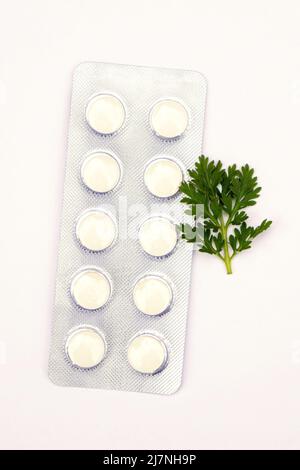 Pills with sprigs of plants on a white background Stock Photo