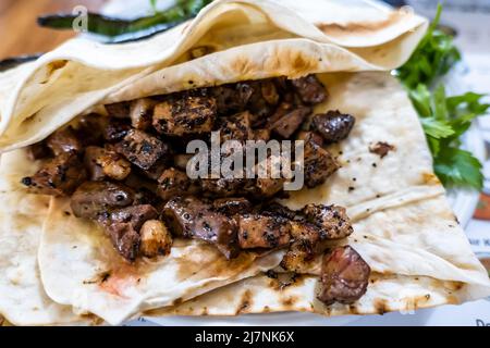 Ciger kabab (Ciğer kebabı in Turkish), a common type of skewered meat served in Anatolian cuisine, usually eaten with sliced onions, salad and bread Stock Photo