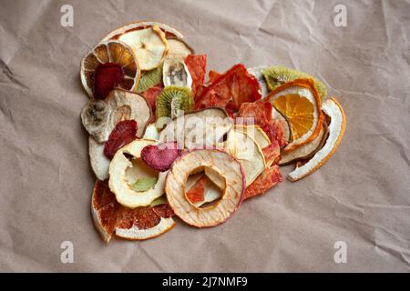 Dried fruit chips heart shaped composition on beige paper background Stock Photo