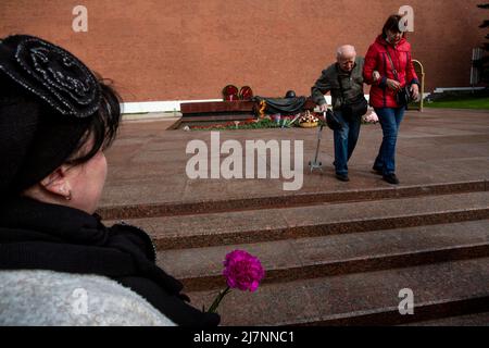 Moscow, Russia. 10th May, 2022. People bring flowers to the monument the Grave of the Unknown Soldier in the Alexander Garden during the celebration of Victory Day on May 9, which marks the 77th anniversary of the Victory over Nazi Germany in World War Two, in central Moscow, Russia. The Tomb of the Unknown Soldier is a war memorial dedicated to the Soviet soldiers killed during World War II Stock Photo