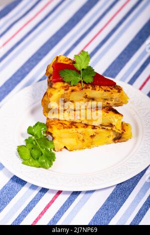 Traditional Spanish starter tortilla patatas served with red piquillo pepper. Stock Photo