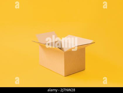 Opened cardboard box on bright yellow background Stock Photo