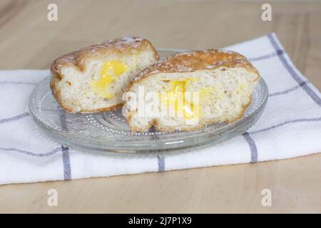 Deep-fried doughnut (paczki or sisky) with Lemon Custard Filling, Lemon Donut cut in half Stock Photo