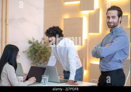 Joyous company employee posing for the camera in the workplace Stock Photo