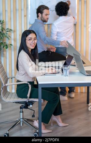 Company worker typing on the laptop during the photo shoot Stock Photo
