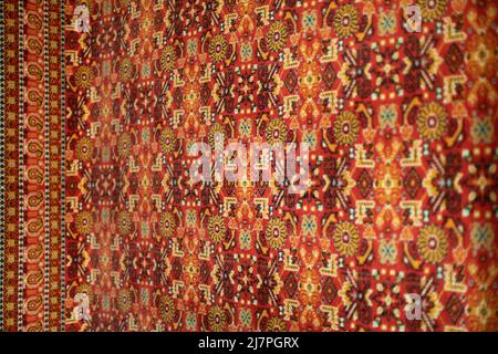 Red carpet in Russia. Fabric with pattern. Traditional carpet on wall. Stock Photo