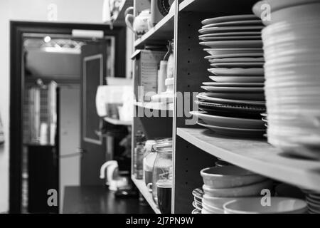 Clean dishes stacked in a kitchen service area Stock Photo