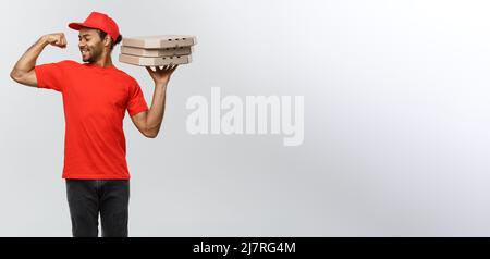 Delivery Concept - Portrait of Strong African American delivery man showing his muscle with pizza box packages. Isolated on Grey studio Background Stock Photo