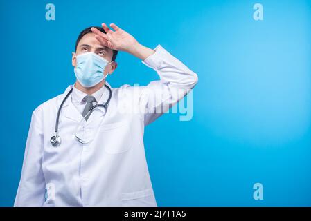 Exhausted doctor in mask and uniform in studio Stock Photo