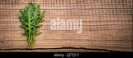Arugula on wooden texture background Stock Photo