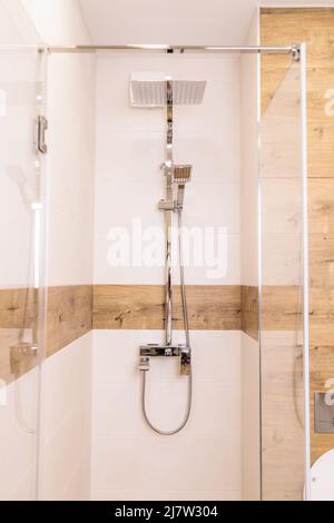 modern bright shower cabin close-up, with water equipment, vertical, wooden background Stock Photo