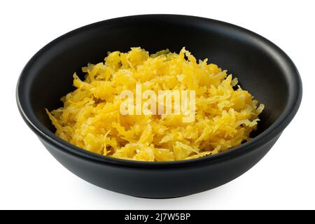 Freshly grated lemon zest in a black ceramic bowl isolated on white. Stock Photo