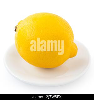 Whole fresh lemon on white ceramic plate isolated on white. Stock Photo