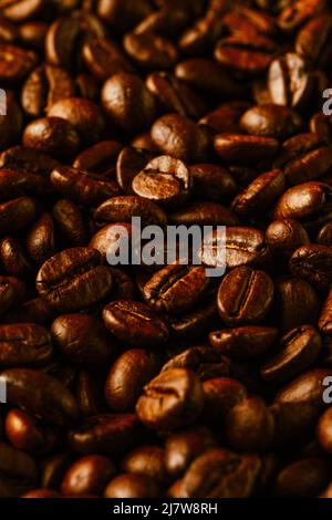 Coffee beans dark abstract background. Vertical seamless pattern with macro roasted brown aromatic robusta grains selective focus shallow depth of fie Stock Photo