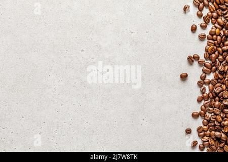 Organic coffee beans border over light stone background. Copy space for text Stock Photo