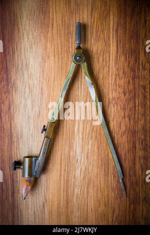 Old vintage pair of compasses on a wooden table background Stock Photo