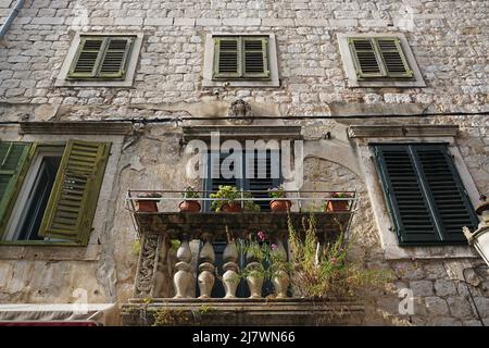 Beautiful old house facade with small balcony and flower pots in the city of Split Stock Photo
