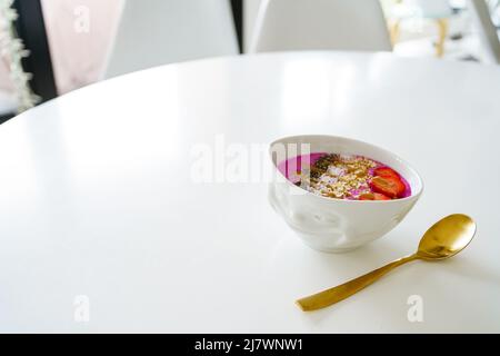 Healthy Pitaya Raspberry Bowl Smoothie Breakfast in porcelain bowl with smile face Stock Photo
