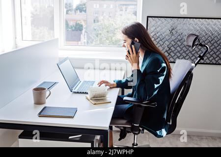 Young female programmer web developer working on computer software in modern office. Web Designer Woman working at her desk in open plan office Stock Photo