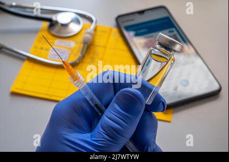 Vaccine with syringe and vaccination card in a doctor's office Stock Photo