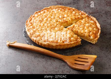 Sliced delicious nut shortcrust tart with caramel close-up on a slate board on the table. horizontal Stock Photo