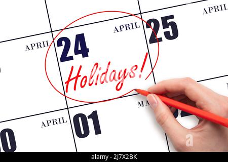 24th day of April.  Hand drawing a red circle and writing the text Holidays on the calendar date 24 April. Important date. Spring month, day of the ye Stock Photo
